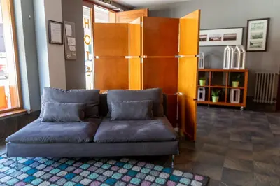 a living room with a couch and a book shelf at Hotel Restaurante San Anton in Tapia de Casariego
