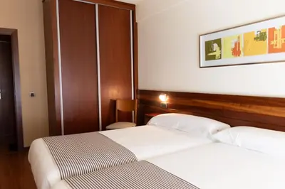 a hotel room with two beds and a picture on the wall at Hotel Restaurante San Anton in Tapia de Casariego