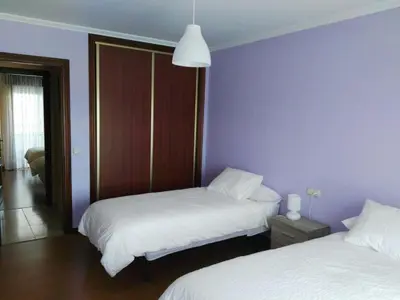 a bedroom with two beds and a purple wall at Arzúa Home in Arzúa