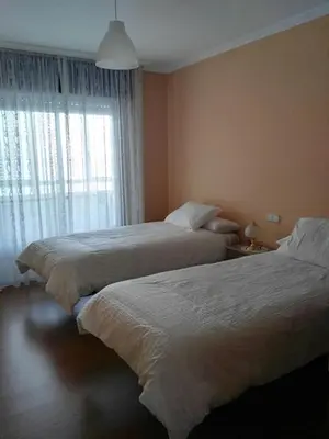 a bedroom with two beds and a window at Arzúa Home in Arzúa