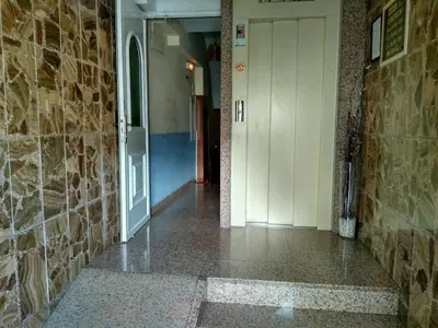 a hallway with a door and a stone wall at Hostal Mayo in O Barco de Valdeorras