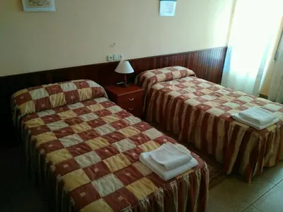 a hotel room with two beds and a lamp at Hostal Mayo in O Barco de Valdeorras
