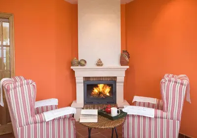 a living room with two chairs and a fireplace at Hotel Rural Suquin in Navia