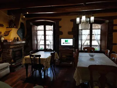 a dining room with a table and a tv at Casa do Catalán - Casa completa - Navia de Suarna in Navia de Suarna
