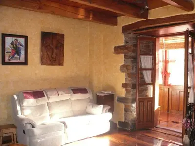 a living room with a white couch and a stone wall at Casa do Catalán - Casa completa - Navia de Suarna in Navia de Suarna