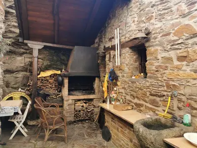a kitchen with a stone wall and an oven at Casa do Catalán - Casa completa - Navia de Suarna in Navia de Suarna