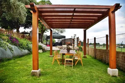a wooden pavilion with a table and chairs in a yard at Casa de Cacheiro - Silleda in Silleda