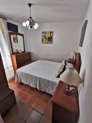 a bedroom with a bed and a table with a lamp at Casa de Cacheiro - Silleda in Silleda