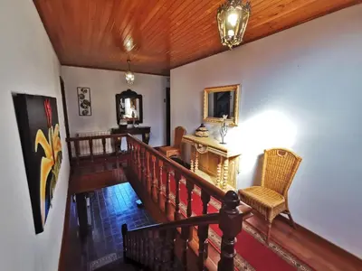 a room with a staircase with a chair and a mirror at Casa de Cacheiro - Silleda in Silleda