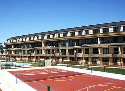 a building with a tennis court in front of a building at Costa Reinante Spa in Barreiros