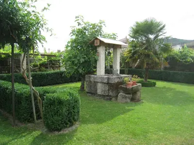 a garden with a stone monument in the grass at O Retiro do Conde in Villaza