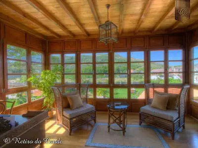 a living room with chairs and a table and windows at O Retiro do Conde in Villaza