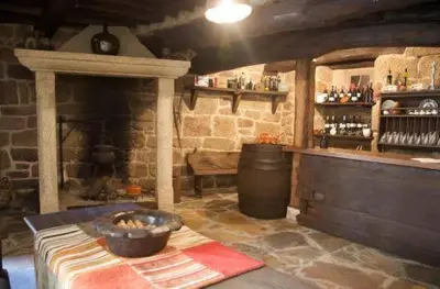 a room with a fireplace and a bar with a barrel at O Retiro do Conde in Villaza