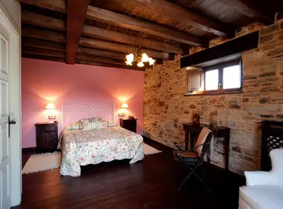a bedroom with a bed and a brick wall at Hotel Casa Cachón in Tol