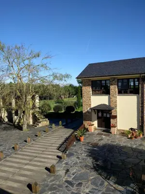 a building with a stone walkway in front of it at Hotel Casa Cachón in Tol
