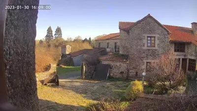 an old stone house in the middle of a yard at Casa rural osvilares in Santiago de Compostela