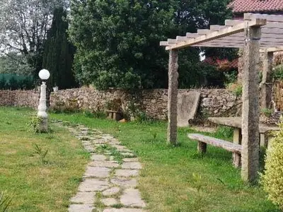 a park with a bench and a stone wall at Casa rural osvilares in Santiago de Compostela