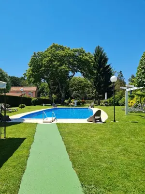 a swimming pool in a park with a grass field at Casa Rustica Neiro in Santiago de Compostela