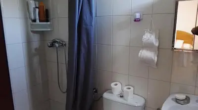 a small bathroom with a shower and a toilet at Casa Rustica Neiro in Santiago de Compostela