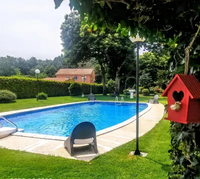 a swimming pool with a bird house next to it at Casa Rustica Neiro in Santiago de Compostela