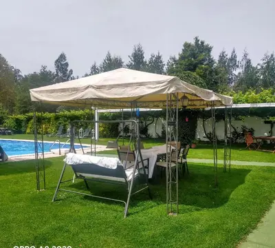 a table and chairs under a tent next to a pool at Casa Rustica Neiro in Santiago de Compostela
