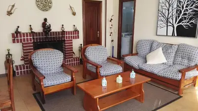 a living room with two chairs and a fireplace at Casa Rustica Neiro in Santiago de Compostela