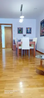 a dining room with a table and chairs on a wooden floor at Apartamento en Sada in Santa María