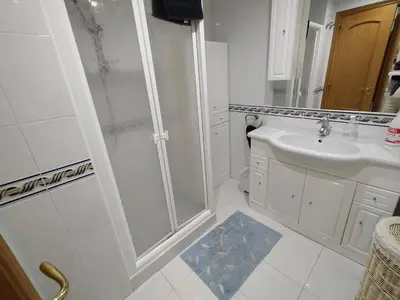 a white bathroom with a shower and a sink at Apartamento en Sada in Santa María