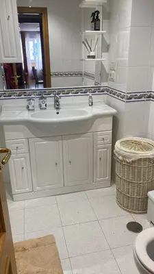 a white bathroom with a sink and a mirror at Apartamento en Sada in Santa María