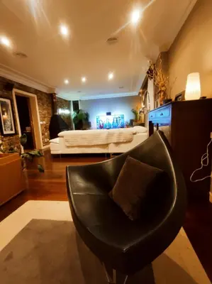 a living room with a black chair and a couch at HHC - Holidays House Compostela in Santiago de Compostela