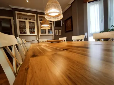 a large wooden table in a room with chairs at HHC - Holidays House Compostela in Santiago de Compostela