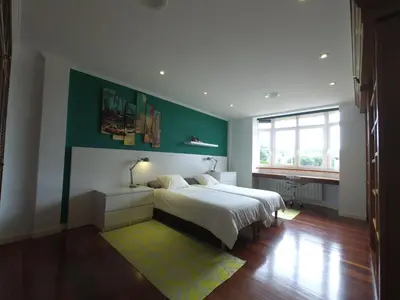 a bedroom with a bed and a green wall at HHC - Holidays House Compostela in Santiago de Compostela
