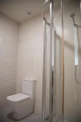 a bathroom with a toilet and a shower at Hostel Cross in Lugo