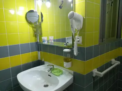 a bathroom with a sink and a blow dryer at Pensión Mar Azul in Santiago de Compostela