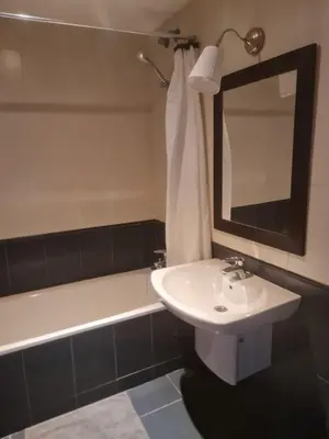 a bathroom with a sink and a bath tub with a mirror at apartamento Tita in Tapia de Casariego