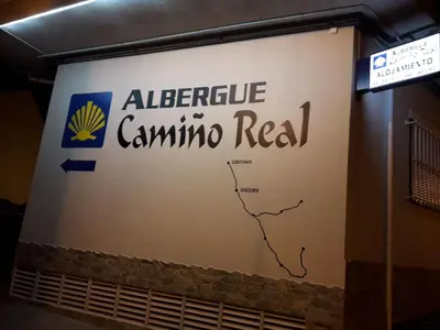 a sign for an alfinance guamino real on a wall at Albergue Camiño Real in Sigüeiro