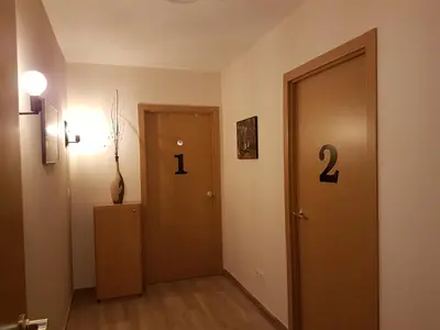 a hallway with a door with two numbers on it at Albergue Camiño Real in Sigüeiro