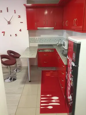 a kitchen with red cabinets and a red refrigerator at Apartamento Centro Frente Muralla in Lugo