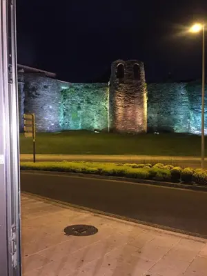 a castle is lit up at night with a street at Apartamento Centro Frente Muralla in Lugo