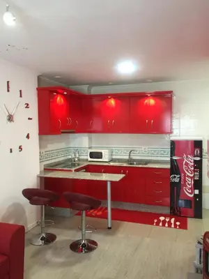 a kitchen with red cabinets and a coke machine at Apartamento Centro Frente Muralla in Lugo