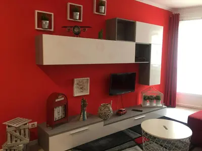 a living room with a red wall at Apartamento Centro Frente Muralla in Lugo