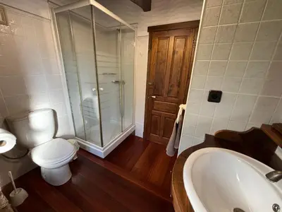 a bathroom with a toilet and a tub and a shower at Eira de Bergondo in Bergondo