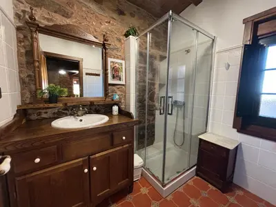 a bathroom with a glass shower and a sink at Eira de Bergondo in Bergondo