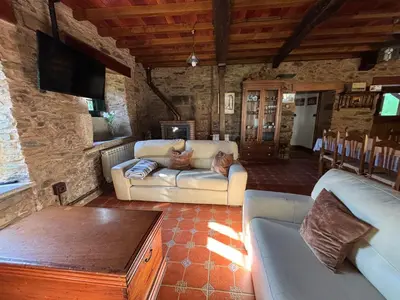 a living room with a couch and a tv at Eira de Bergondo in Bergondo