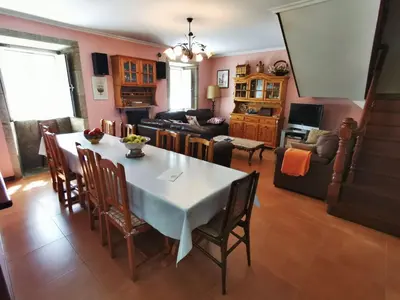 a dining room and living room with a table and chairs at Casa Duarte in Cuntis