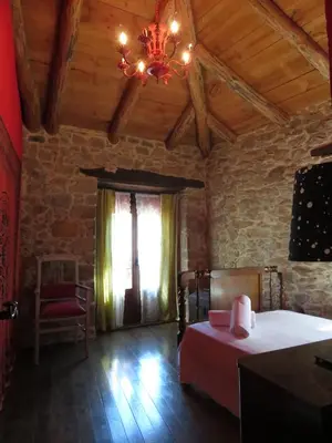 a bedroom with a bed and a chandelier at Neverending Bierzo in Pobladura de las Regueras