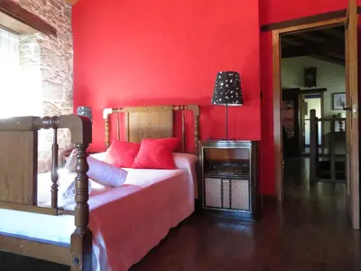 a bedroom with red walls and a bed with red pillows at Neverending Bierzo in Pobladura de las Regueras