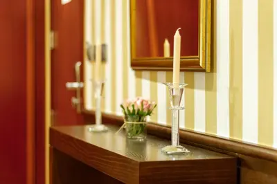 a bathroom counter with two candles and a vase of flowers at Hotel MIRAVALLE in Ourense