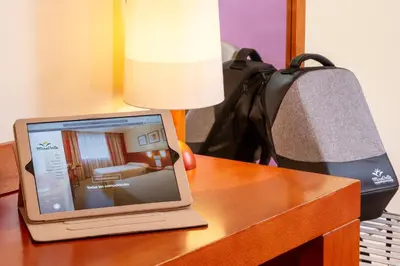 a laptop computer sitting on a table with a lamp at Hotel MIRAVALLE in Ourense