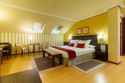 a hotel room with a bed and a table and chairs at Hotel MIRAVALLE in Ourense